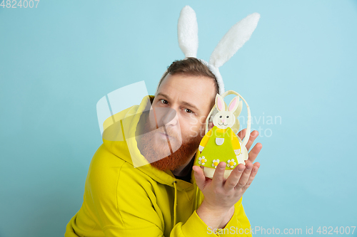 Image of Easter bunny man with bright emotions on blue studio background