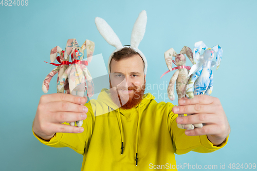 Image of Easter bunny man with bright emotions on blue studio background