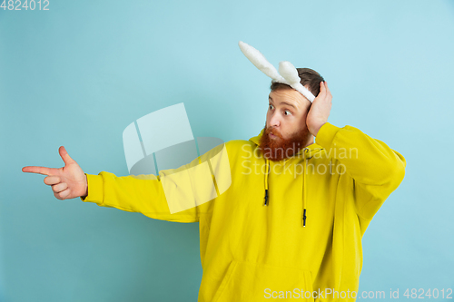 Image of Easter bunny man with bright emotions on blue studio background