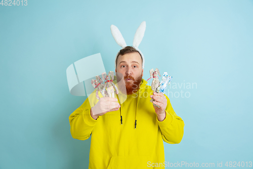 Image of Easter bunny man with bright emotions on blue studio background