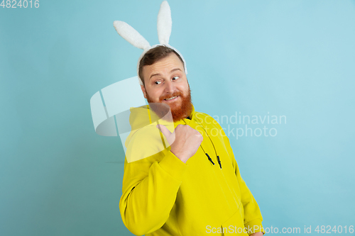 Image of Easter bunny man with bright emotions on blue studio background