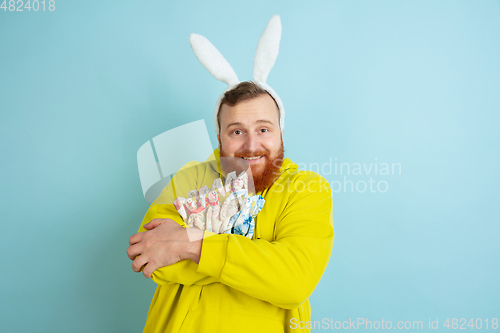 Image of Easter bunny man with bright emotions on blue studio background