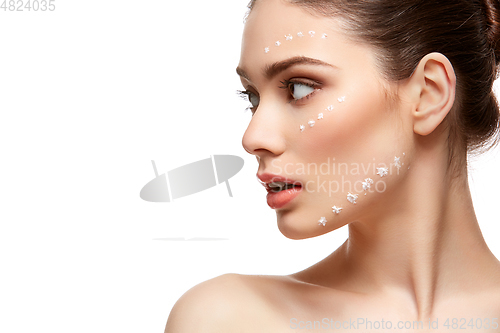 Image of girl applying foundation on face isolated on white