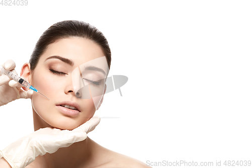 Image of beautiful girl getting face injection isolated on white