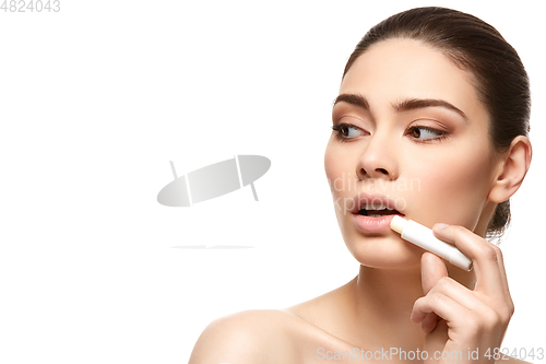 Image of girl applying pink lipstick isolated on white