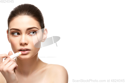 Image of girl applying pink lipstick isolated on white