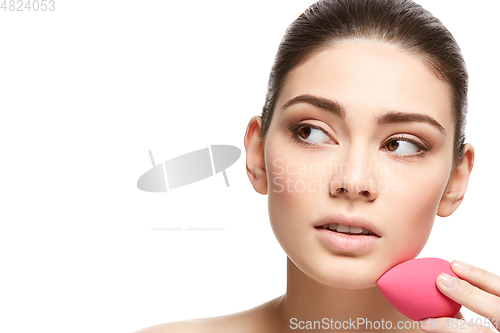 Image of girl with makeup sponge isolated on white