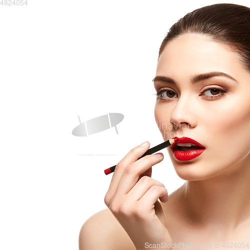 Image of girl applying red lipstick isolated on white