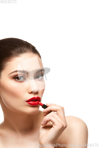 Image of girl applying red lipstick isolated on white