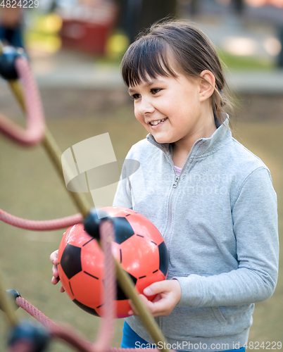 Image of Cute little girl is playing in playground