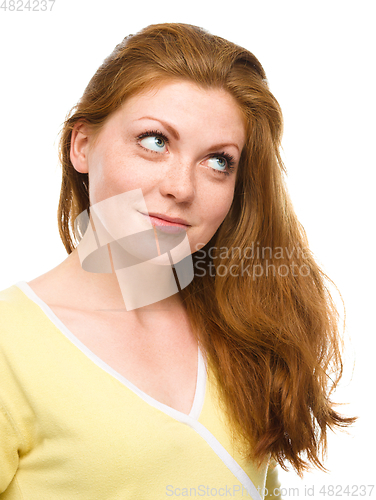 Image of Young happy woman is looking up and smile