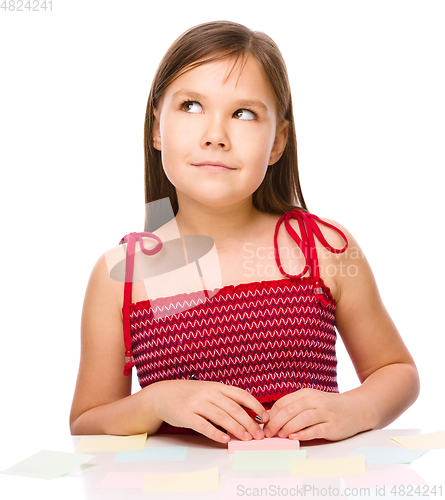 Image of Girl is writing on color stickers using pen