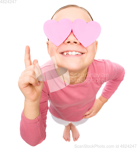 Image of Little girl is holding hearts over her eyes