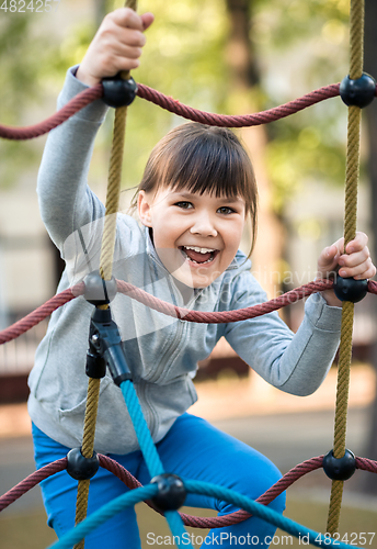 Image of Cute little girl is playing in playground