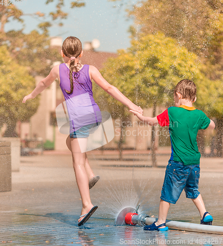 Image of Girl and boy are enjoying fountain