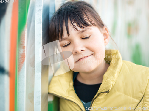 Image of Cute little girl is playing in playground