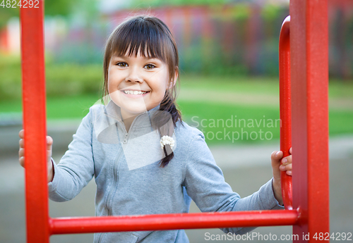 Image of Cute little girl is playing in playground