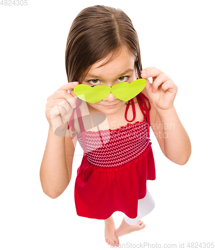 Image of Girl is looking over her heart-shaped glasses