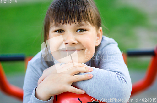 Image of Cute little girl is playing in playground