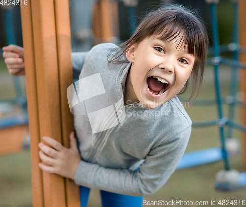 Image of Cute little girl is playing in playground