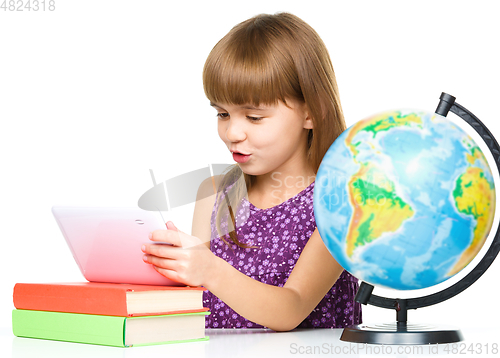 Image of Young girl is using tablet while studying