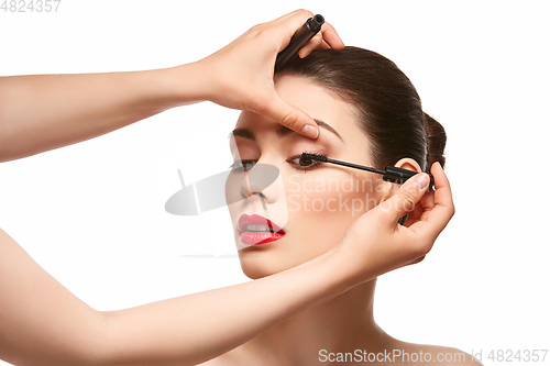 Image of girl applying eyelash mascara isolated on white