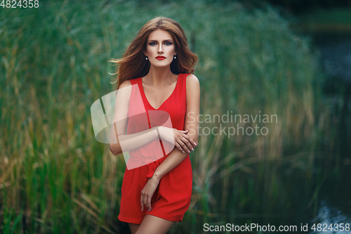 Image of beautiful girl wiith red lips near lake