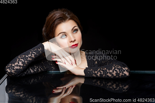 Image of beautiful young woman with red lips on black