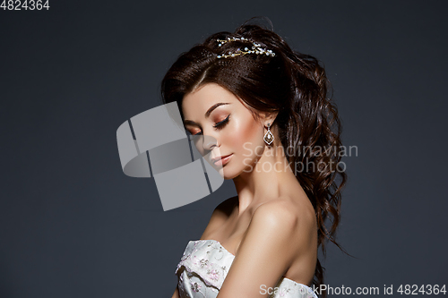 Image of beautiful bride in wedding gown on grey background