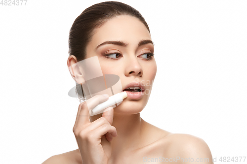 Image of girl applying pink lipstick isolated on white