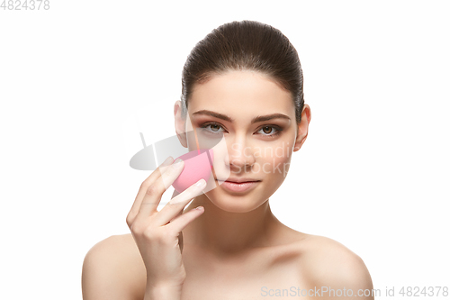 Image of girl with makeup sponge isolated on white