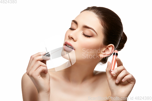 Image of girl applying pink lipstick isolated on white