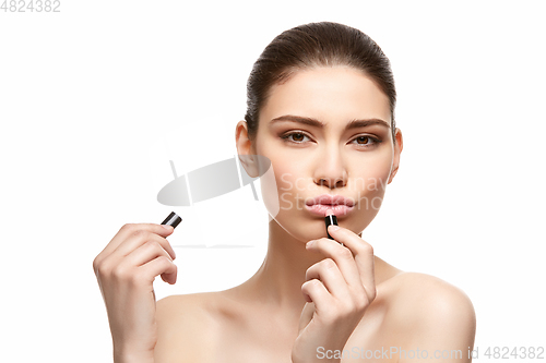 Image of girl applying pink lipstick isolated on white