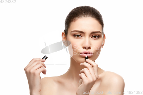 Image of girl applying pink lipstick isolated on white