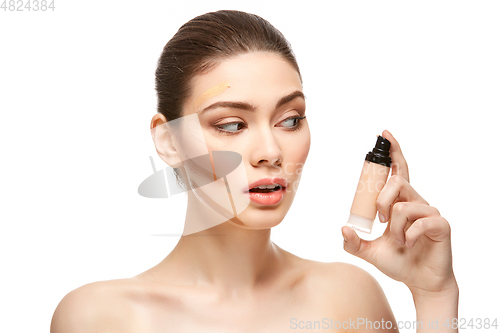 Image of girl applying foundation on face isolated on white