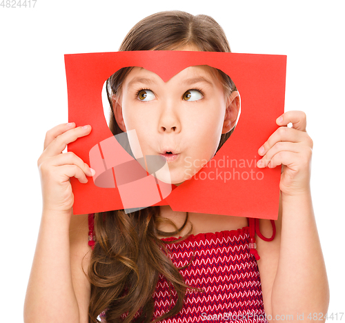 Image of Little girl is looking through heart template