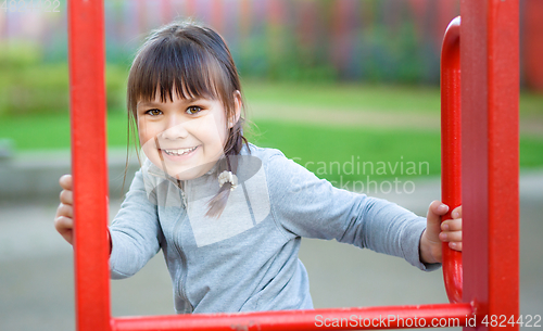 Image of Cute little girl is playing in playground