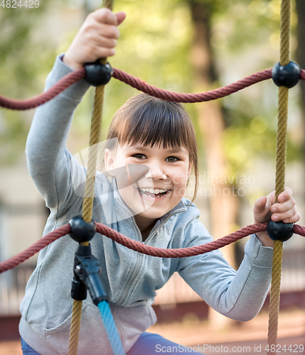 Image of Cute little girl is playing in playground