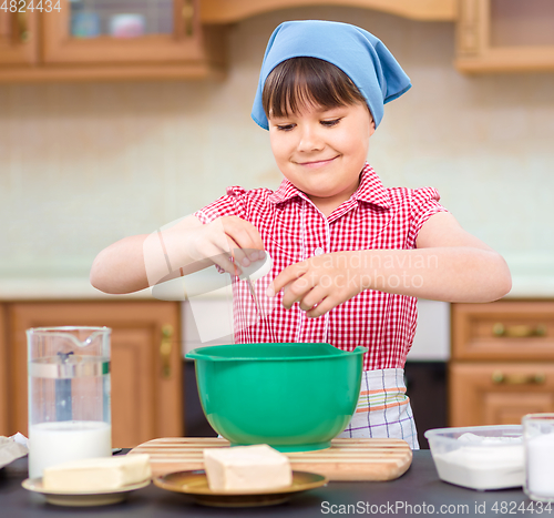 Image of Girl is cooking in kitchen