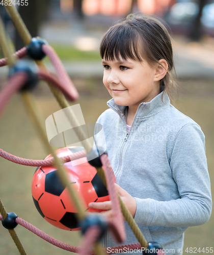 Image of Cute little girl is playing in playground