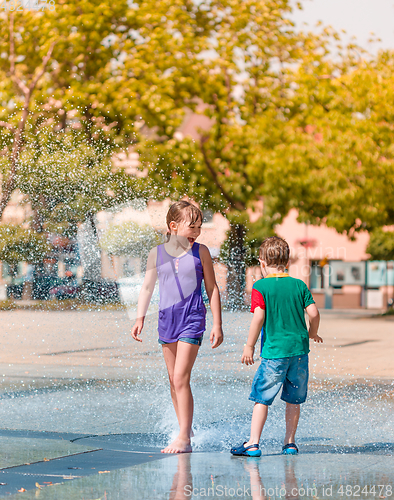 Image of Girl and boy are enjoying fountain