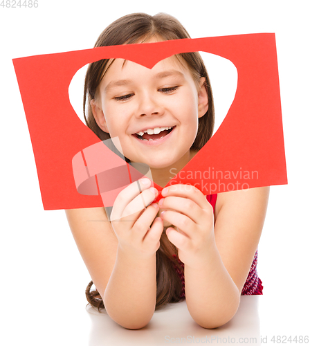 Image of Little girl is looking through heart template