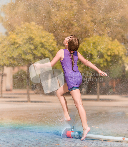 Image of Girl is enjoying fountain with cold water