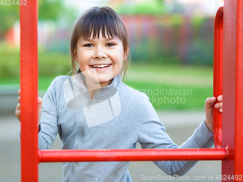 Image of Cute little girl is playing in playground