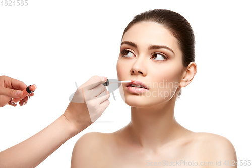 Image of girl applying pink lipstick isolated on white