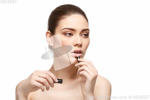 Image of girl applying pink lipstick isolated on white