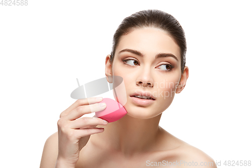 Image of girl with makeup sponge isolated on white