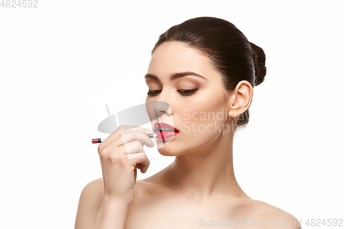 Image of girl applying red lipstick isolated on white