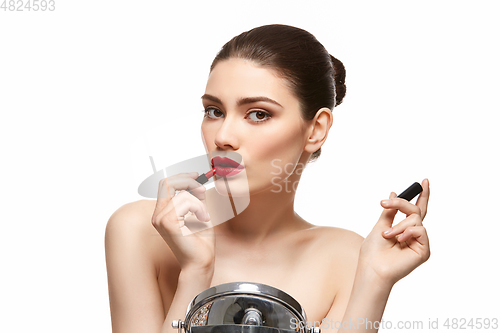 Image of girl applying red lipstick isolated on white