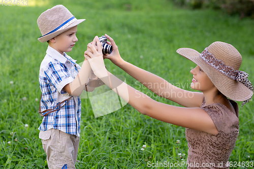 Image of handsome little boy with retro camera and girl model